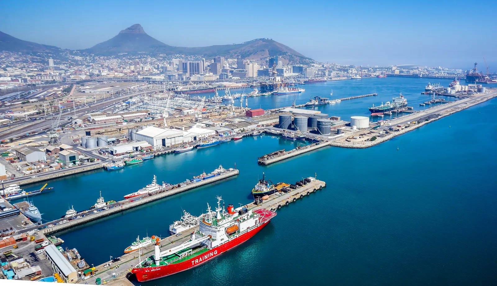 Aerial view of the Port of Cape Town with docks, moored ships and the city below Table Mountain and Lion's Head